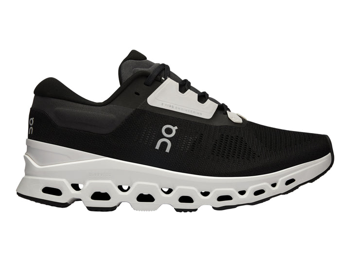 Tenis deportivos On Cloudstratus 3 en color negro con suela blanca gruesa y diseño moderno.