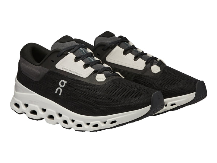 Tenis deportivos On Cloudstratus 3 en color negro con suela blanca gruesa y diseño moderno.