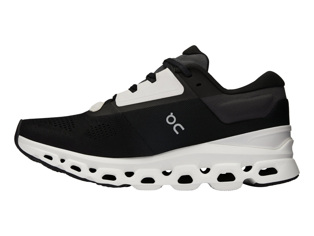 Tenis deportivos On Cloudstratus 3 en color negro con suela blanca gruesa y diseño moderno.