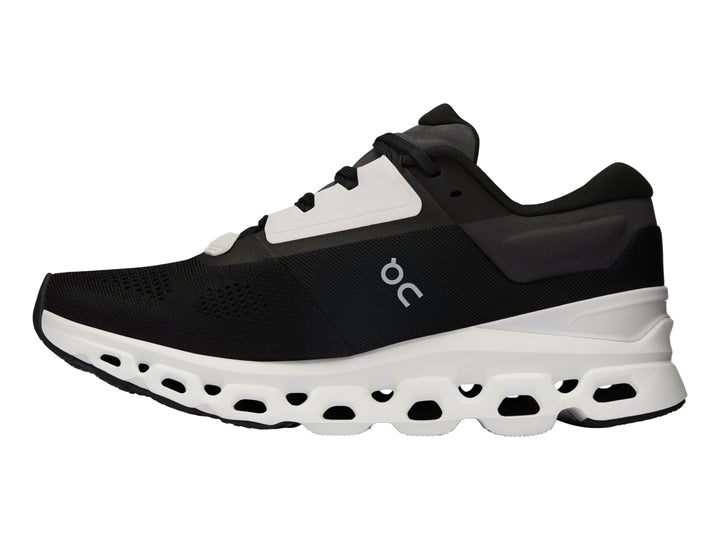 Tenis deportivos On Cloudstratus 3 en color negro con suela blanca gruesa y diseño moderno.