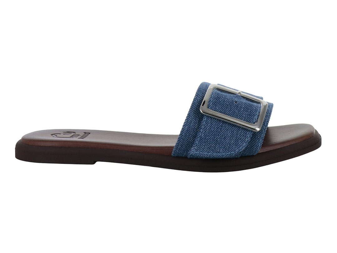 Sandalia plana para niña de color azul cielo en mezclilla con hebilla plateada y suela marrón.