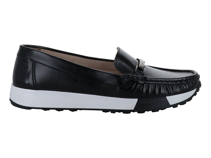 Zapato mocasín negro con suela blanca gruesa y detalle metálico superior.