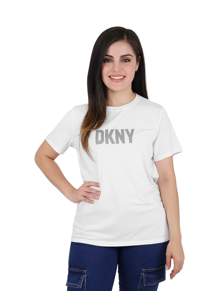 Mujer vistiendo una camiseta blanca de manga corta con el logo de DKNY en el pecho.