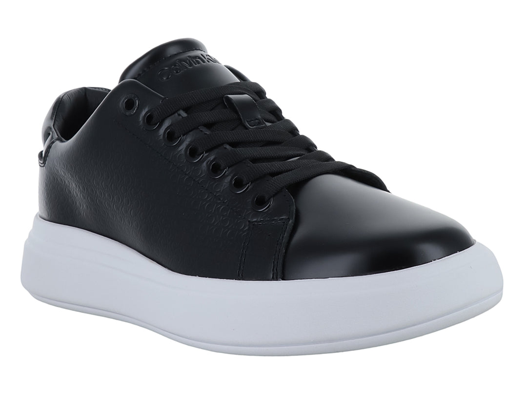 Tenis Calvin Klein color negro con suela blanca gruesa y textura grabada en el cuerpo.
