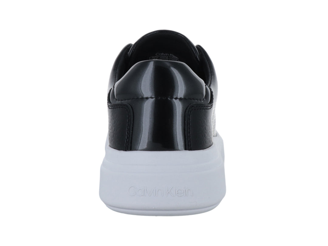Tenis Calvin Klein color negro con suela blanca gruesa y textura grabada en el cuerpo.