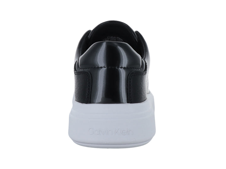 Tenis Calvin Klein color negro con suela blanca gruesa y textura grabada en el cuerpo.