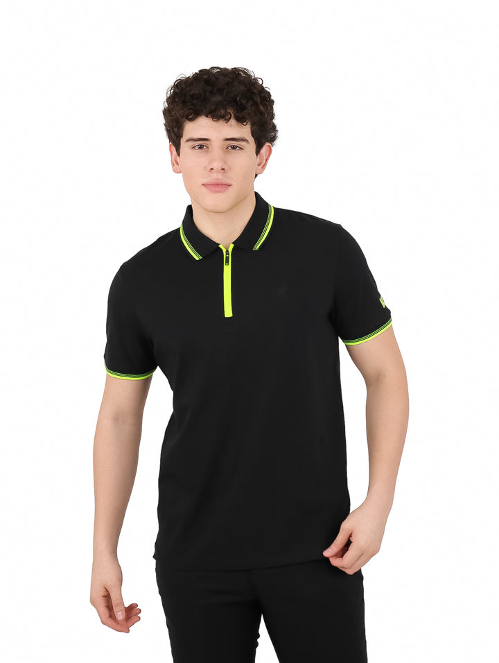 Hombre vistiendo polo DKNY color negro con detalles en amarillo neón en el cuello, mangas y cierre frontal.
