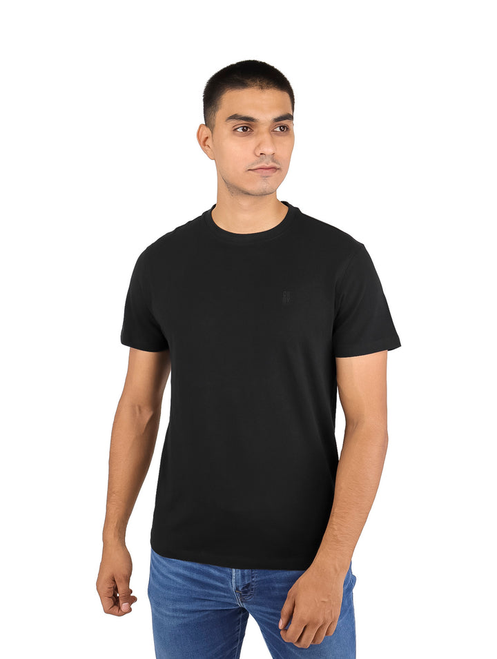 Hombre vistiendo una camiseta básica de manga corta y cuello redondo en color negro.