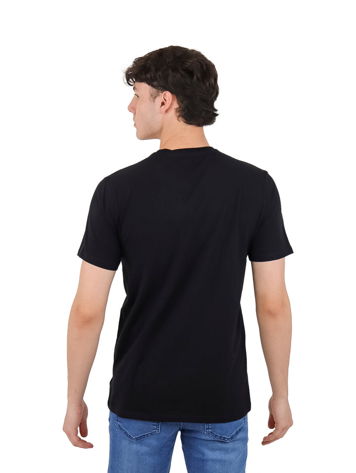 Hombre vistiendo una camiseta negra de manga corta con el logotipo DKNY en letras grandes y blancas en el pecho.