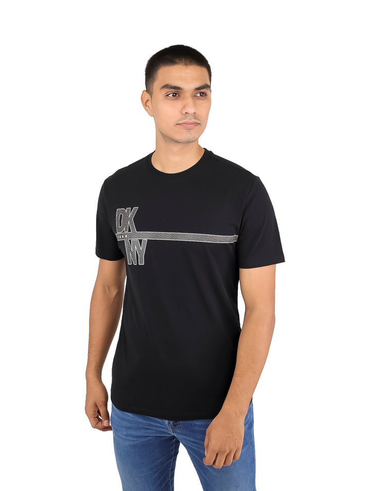 Hombre vistiendo una camiseta negra de manga corta con logotipo DKNY en el pecho.