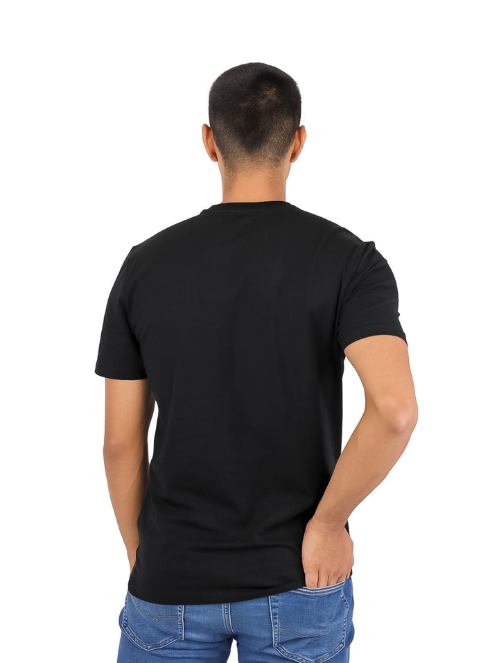 Hombre vistiendo una camiseta negra de manga corta con logotipo DKNY en el pecho.