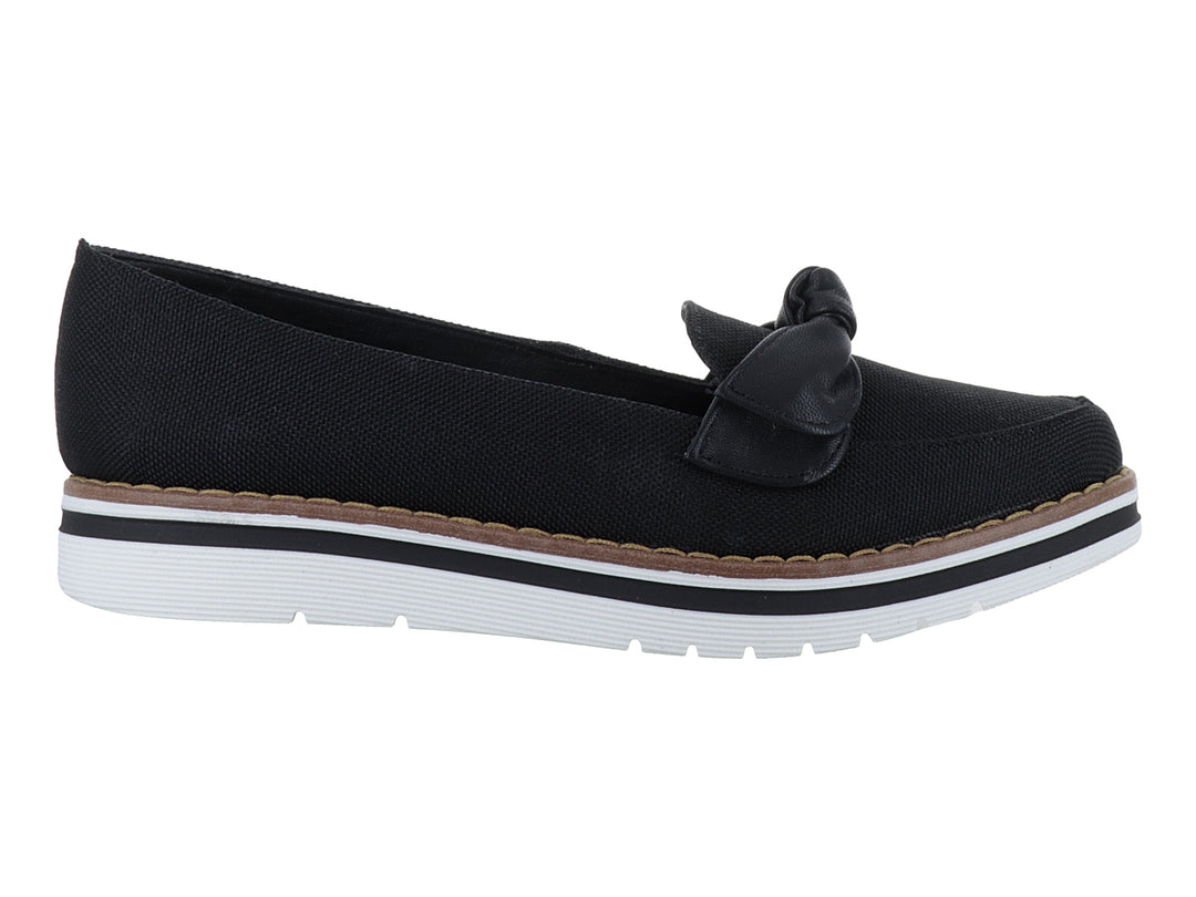 Zapato plano color negro con moño decorativo y suela blanca con detalle café.