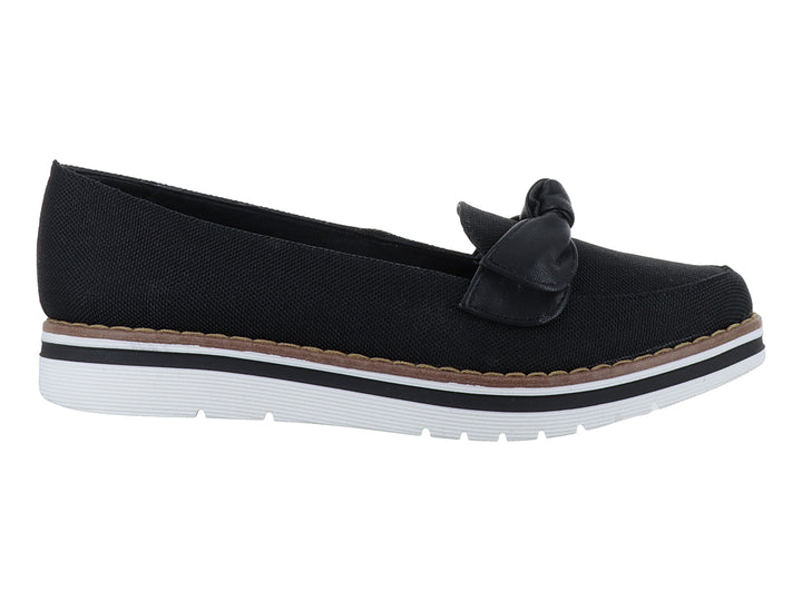 Zapato plano color negro con moño decorativo y suela blanca con detalle café.