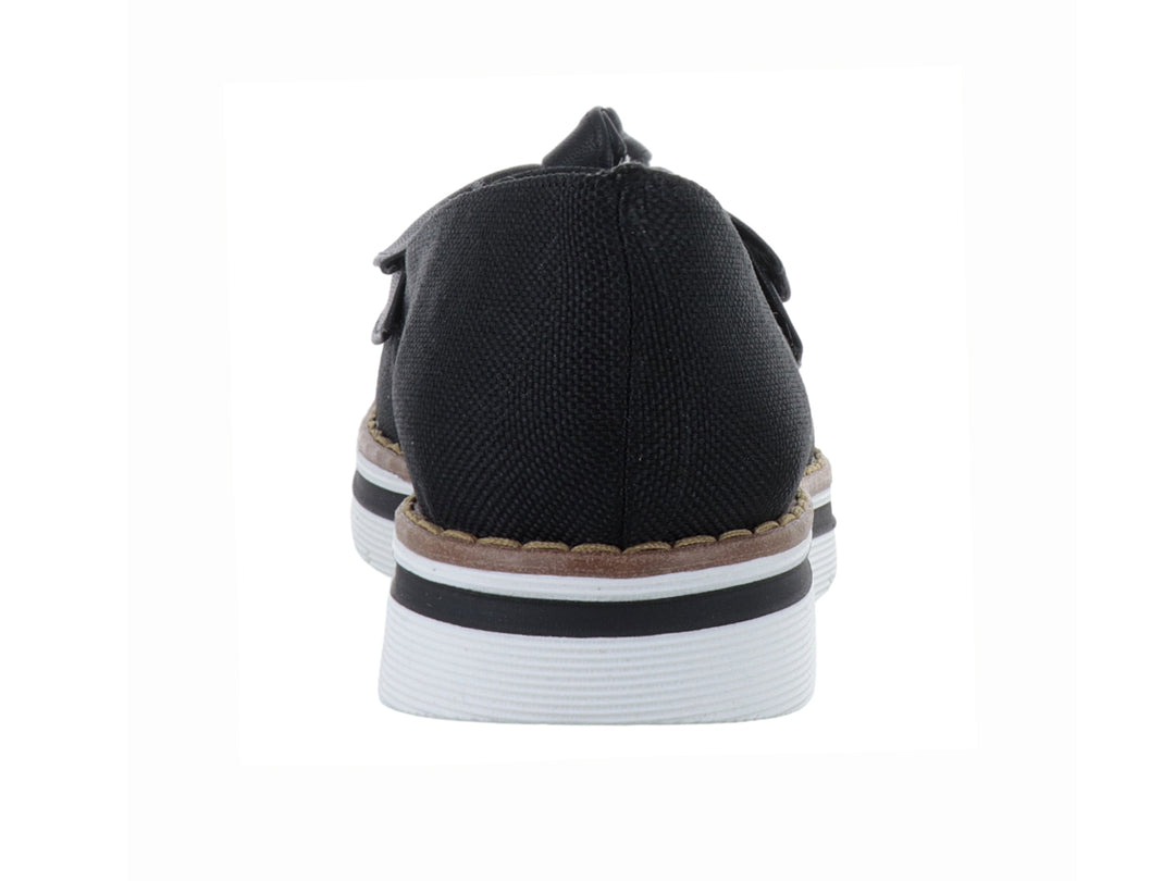 Zapato plano color negro con moño decorativo y suela blanca con detalle café.