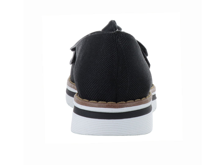 Zapato plano color negro con moño decorativo y suela blanca con detalle café.
