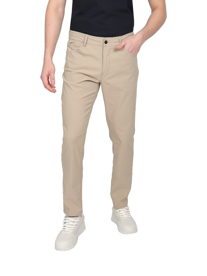 Hombre vistiendo pantalones de gabardina color khaki de corte ajustado y tenis blancos.