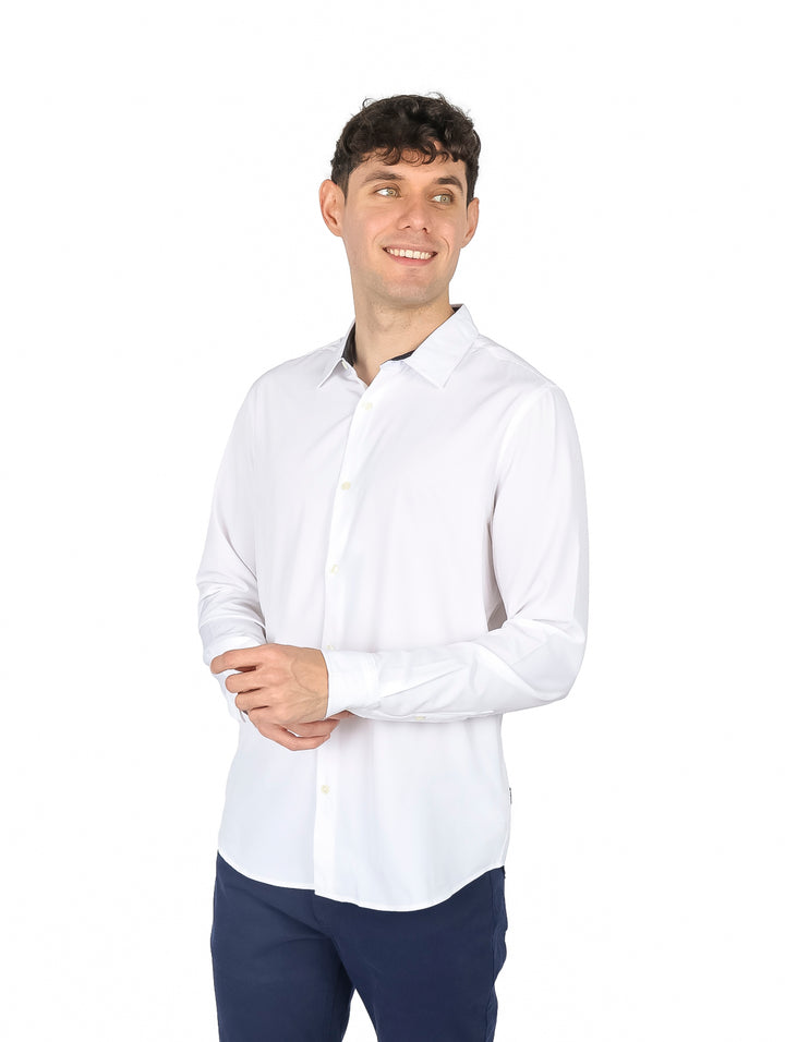 Hombre vistiendo una camisa blanca de manga larga con cuello y botones.
