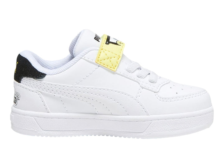 Tenis PUMA blancos para niño con detalles en negro y amarillo, cierre de agujetas y correa de velcro.