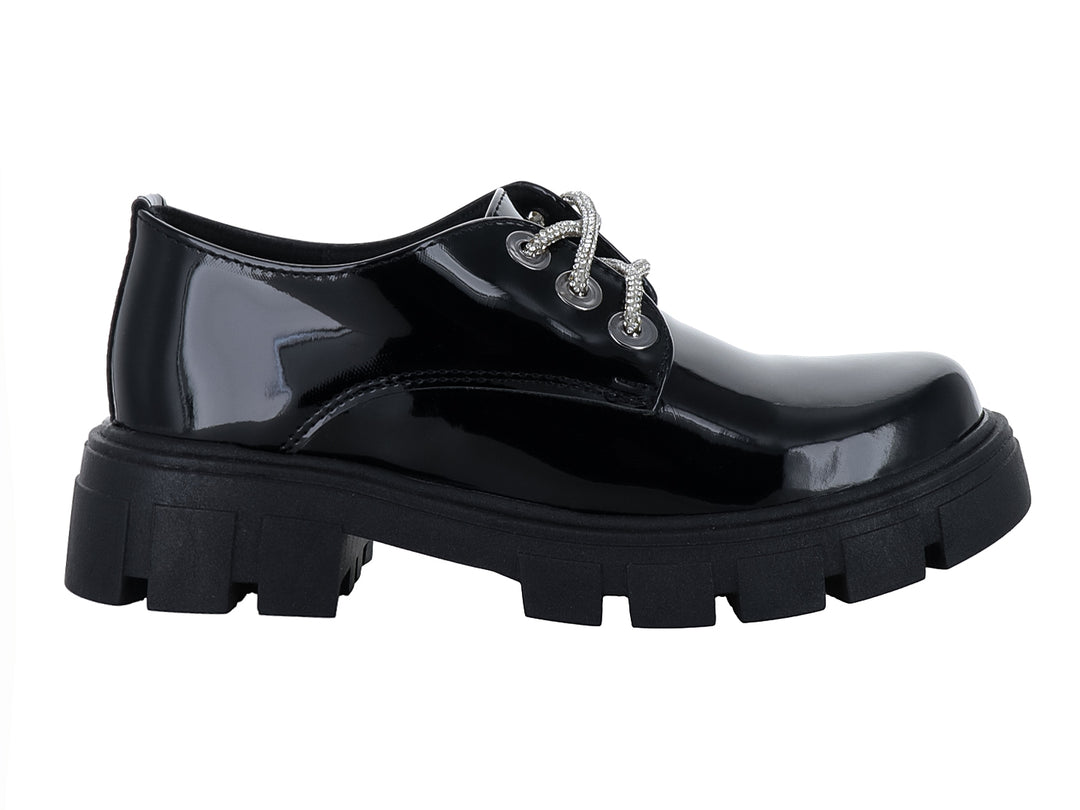 Zapato de charol negro para niña con cordones blancos y suela track gruesa.