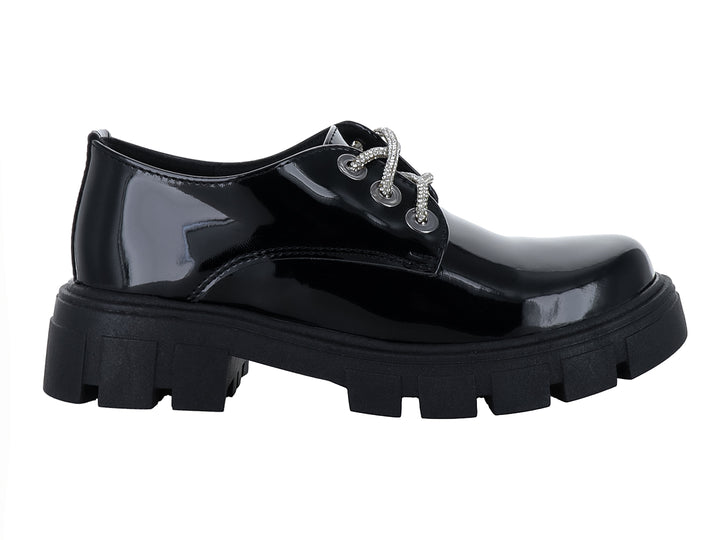 Zapato de charol negro para niña con cordones blancos y suela track gruesa.