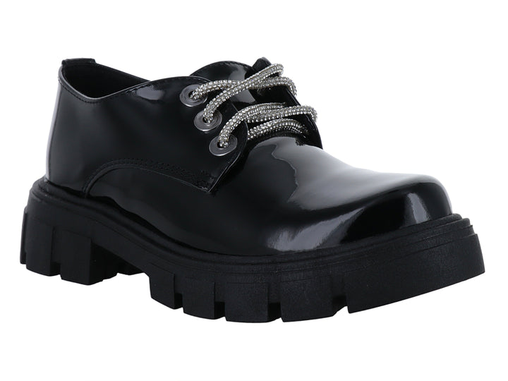Zapato de charol negro para niña con cordones blancos y suela track gruesa.