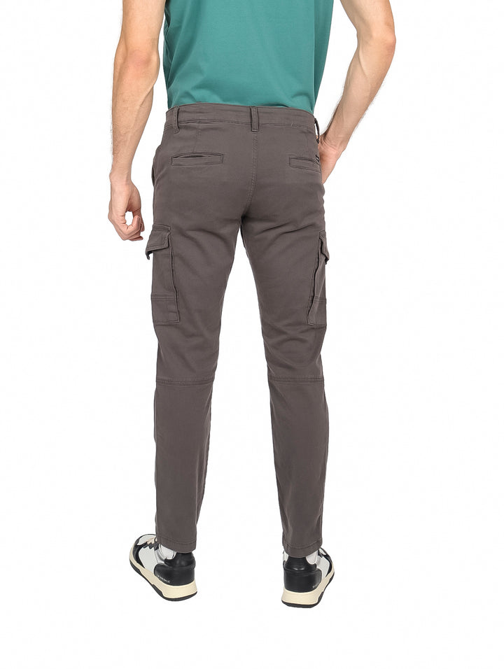 Hombre vistiendo pantalón slim fit color gris oscuro con bolsillos laterales estilo cargo.