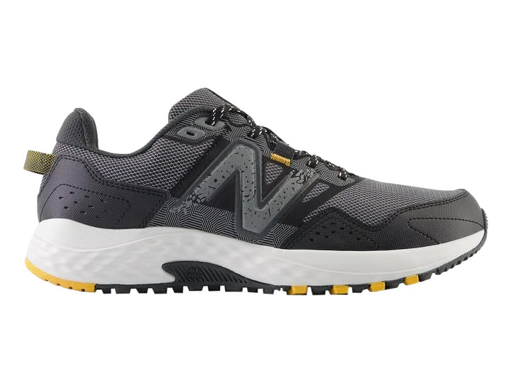 Tenis deportivos New Balance color gris Castlerock con suela blanca y detalles amarillos.