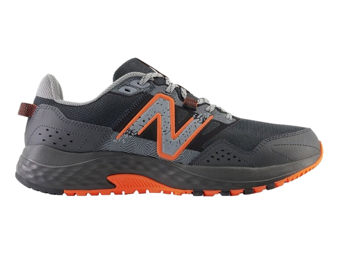 Tenis New Balance color negro y gris con suela y detalles en color naranja.