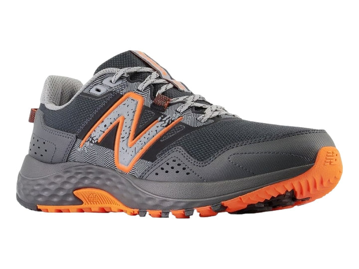 Tenis New Balance color negro y gris con suela y detalles en color naranja.