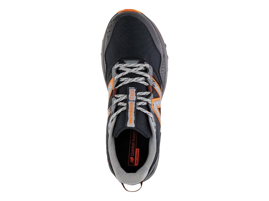 Tenis New Balance color negro y gris con suela y detalles en color naranja.