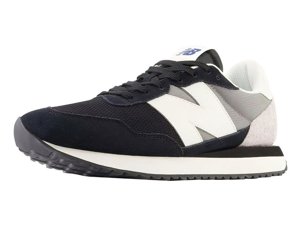 Tenis New Balance negros con detalles en blanco y gris y suela blanca dentada.