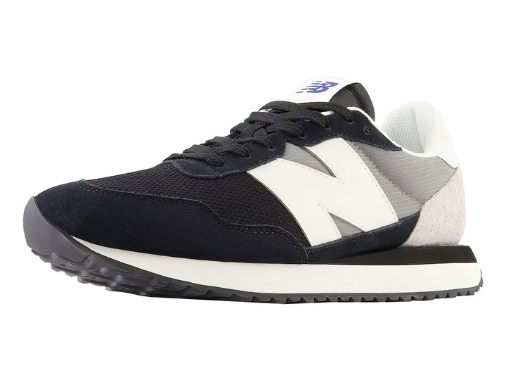 Tenis New Balance negros con detalles en blanco y gris y suela blanca dentada.