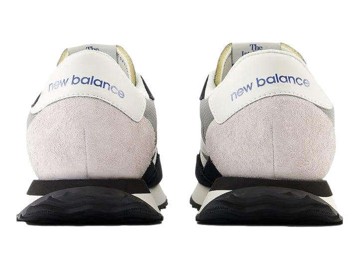 Tenis New Balance negros con detalles en blanco y gris y suela blanca dentada.