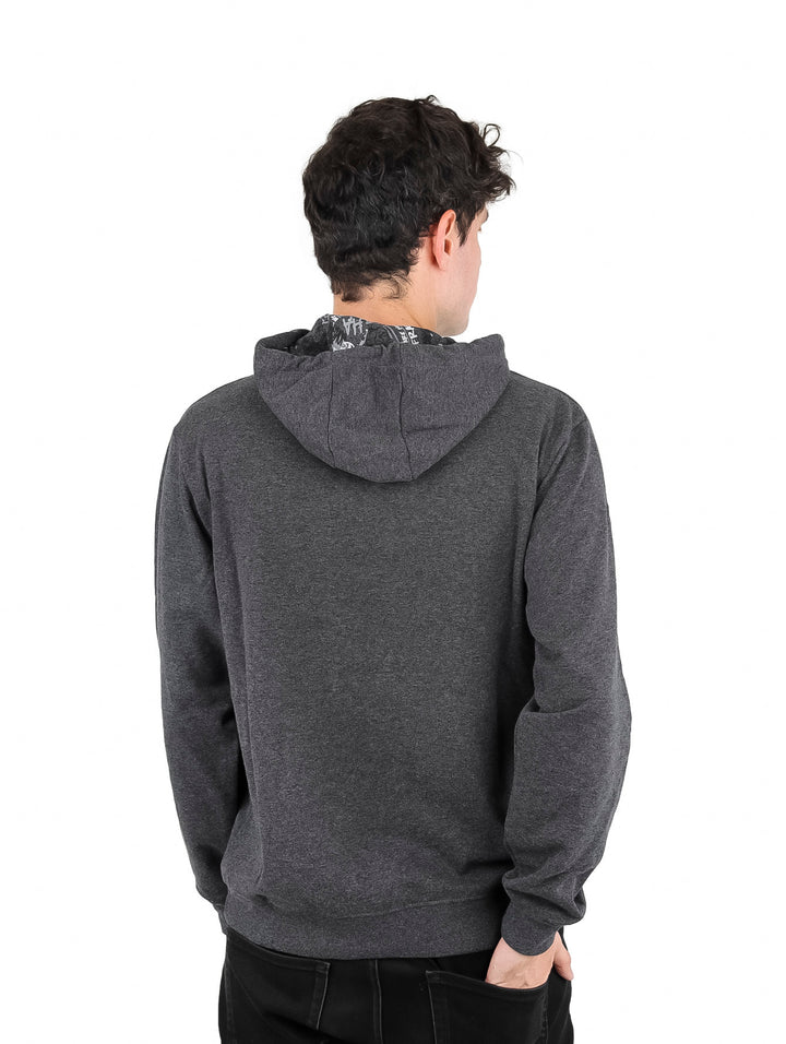 Hombre vistiendo sudadera con capucha color gris oxford con logo de Batman en el pecho.
