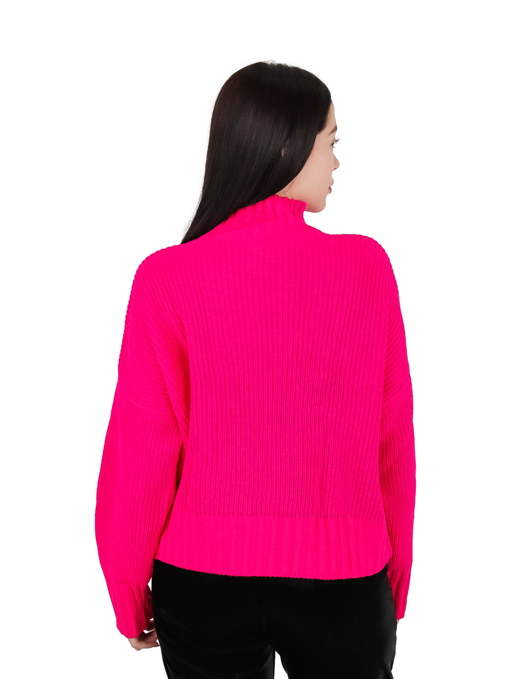 Mujer vistiendo un suéter fucsia de cuello alto adornado con piedras coloridas.