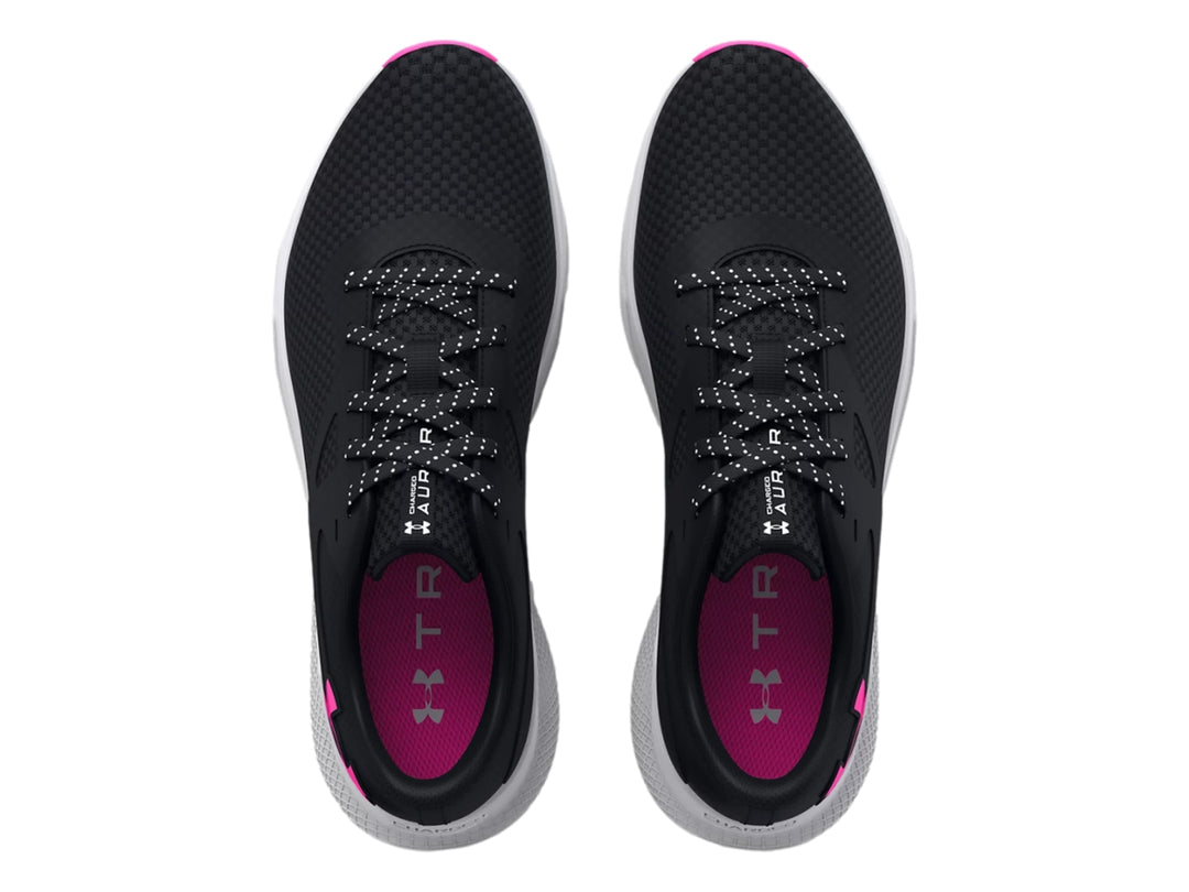 Tenis deportivos Under Armour color negro con suela blanca y detalles en rosa.
