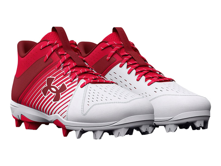 Zapato deportivo Under Armour color rojo y blanco con suela de tacos para deporte.