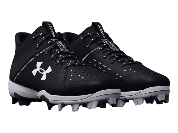 Zapato deportivo Under Armour Leadoff Mid RM JR color negro con suela gris y tacos.