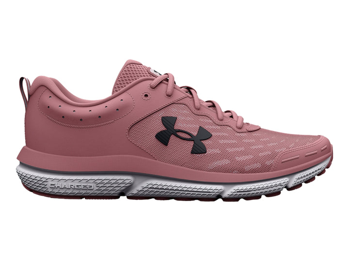 Tenis deportivos Under Armour color rosa con suela gris y blanca, vista lateral.