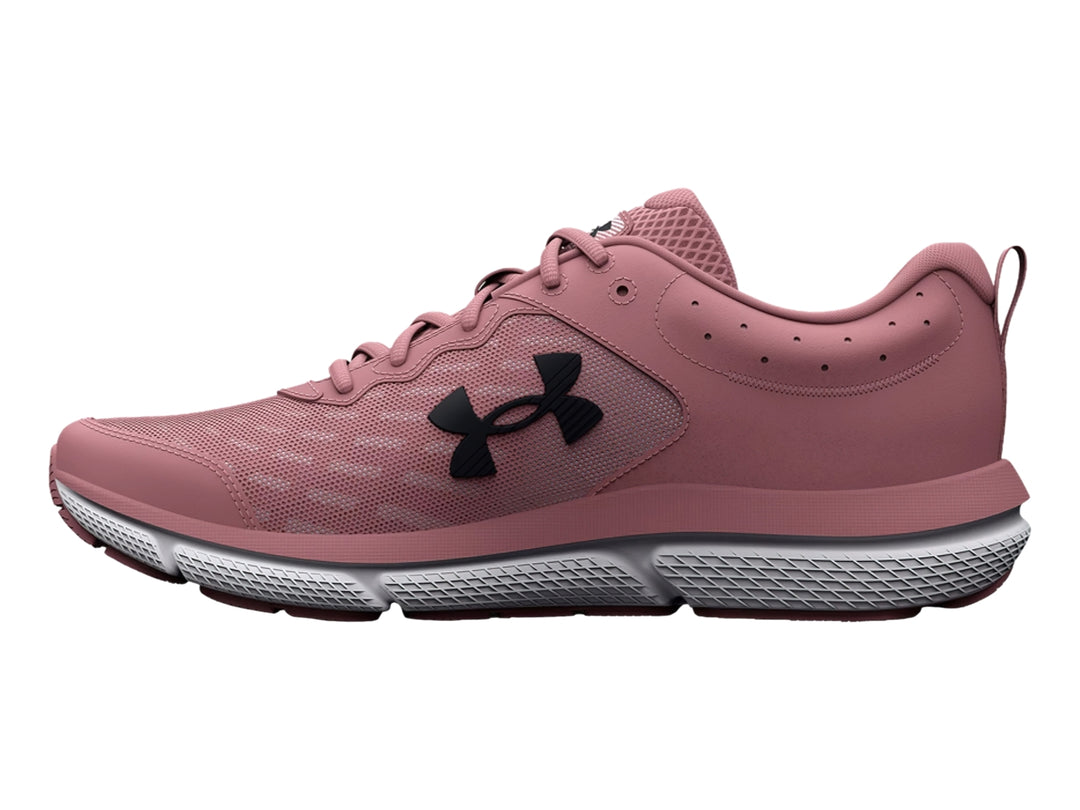 Tenis deportivos Under Armour color rosa con suela gris y blanca, vista lateral.