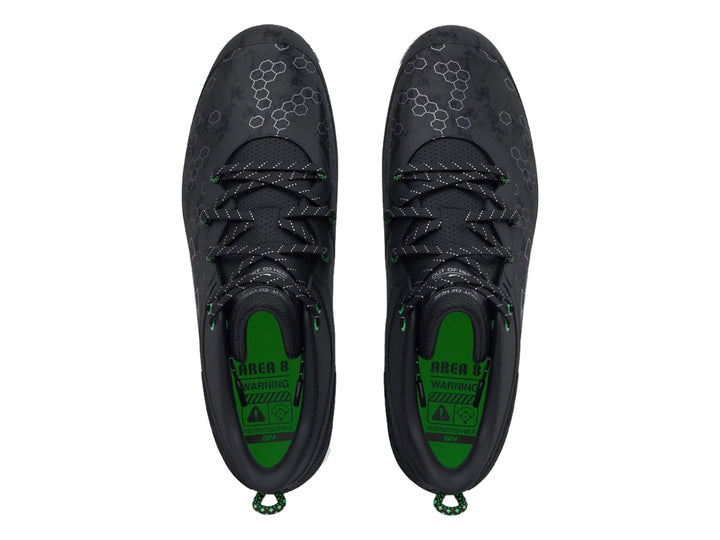 Zapato deportivo Under Armour Harper 8 Mid en color negro con detalles verdes y suela blanca para béisbol.