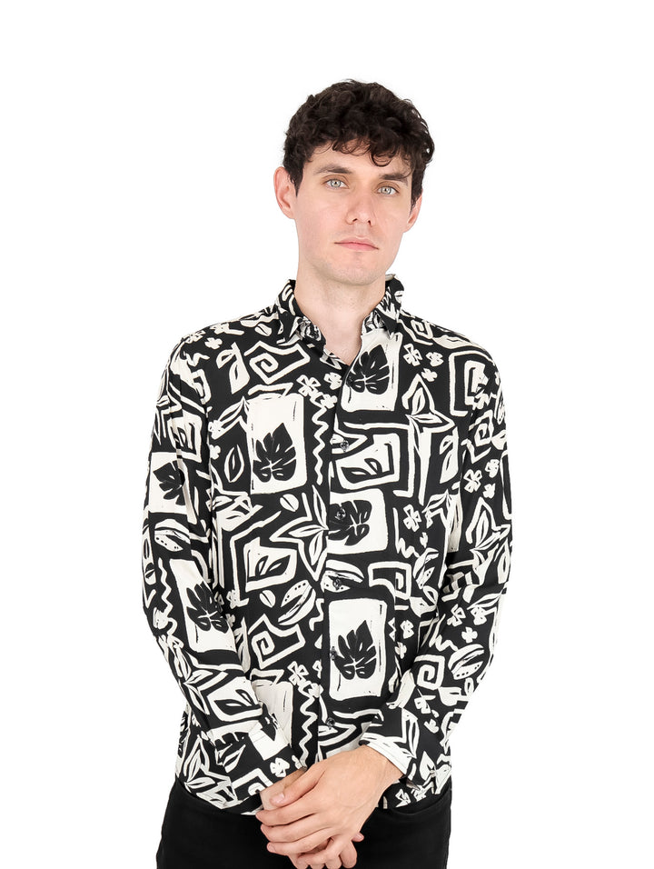 Hombre vistiendo camisa de manga larga con estampado geométrico en colores blanco y negro.