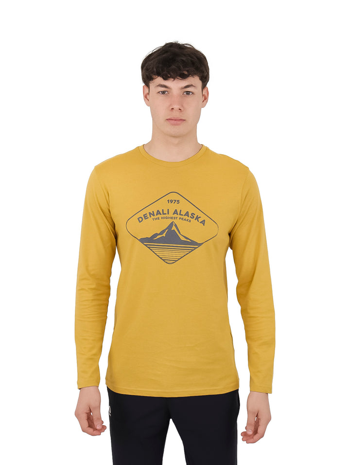 Hombre vistiendo playera de manga larga color amarillo oscuro con estampado frontal de Denali Alaska.