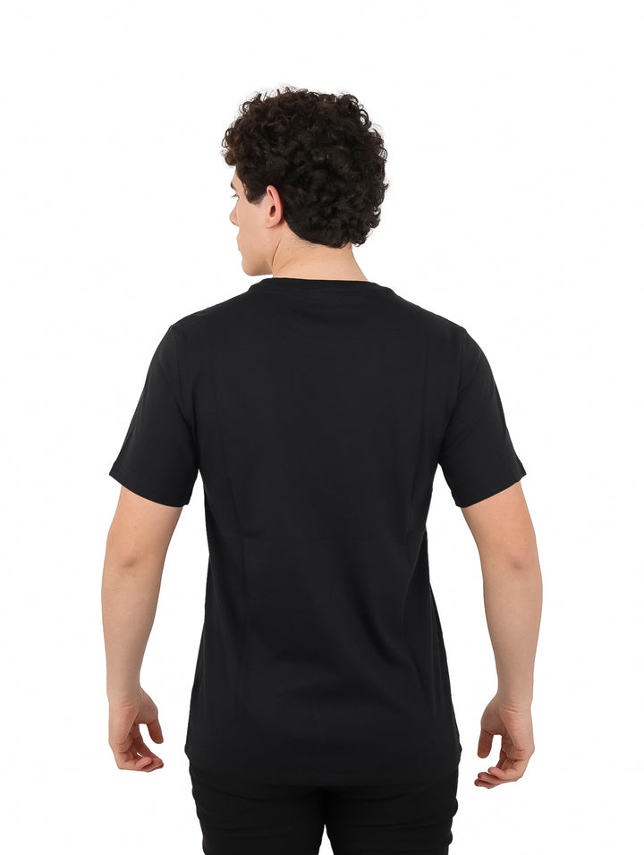 Hombre vistiendo camiseta negra de manga corta con estampado circular de Converse All Star en el pecho.