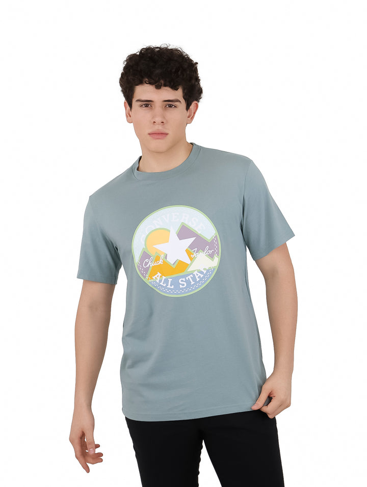Hombre vistiendo camiseta Converse color gris Tidepool con gráfico circular colorido en el pecho.