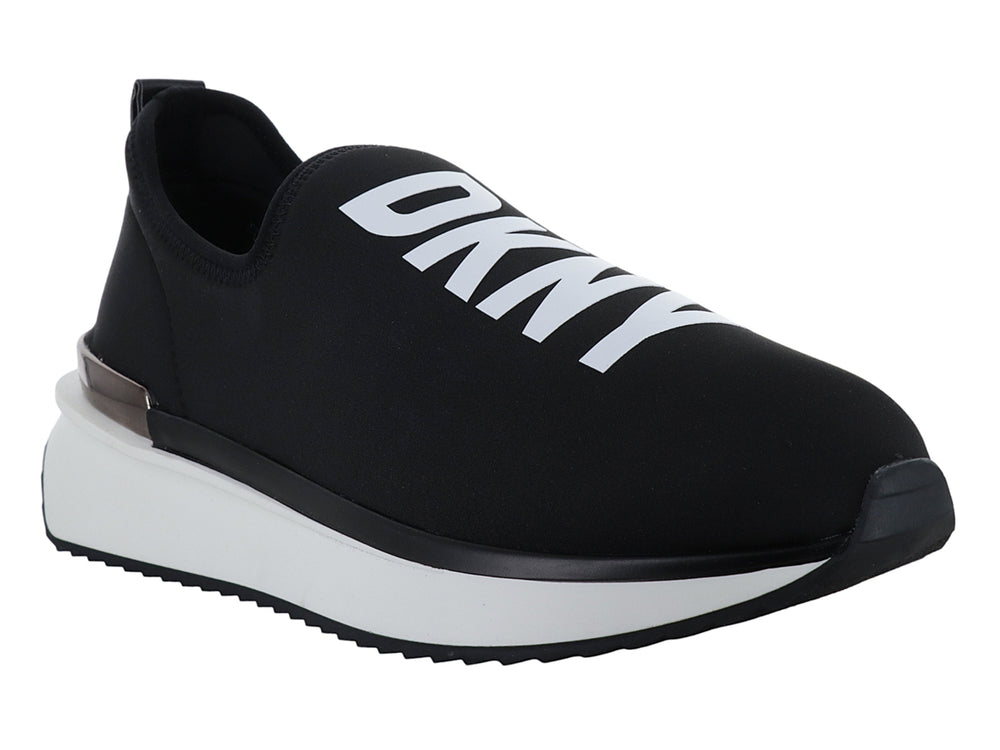 Tenis DKNY slip-on color negro con suela blanca y detalle metálico en el talón.