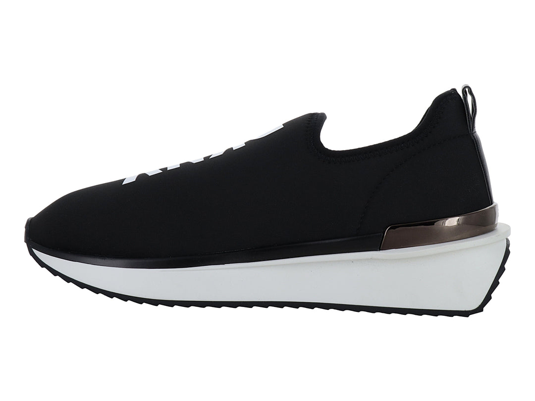 Tenis DKNY slip-on color negro con suela blanca y detalle metálico en el talón.