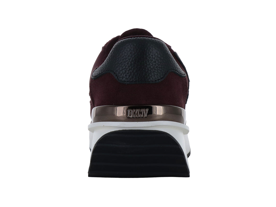 Tenis DKNY color bordeaux con suela blanca de plataforma y detalle dorado en el talón.