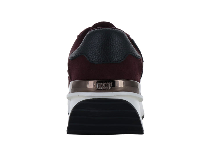 Tenis DKNY color bordeaux con suela blanca de plataforma y detalle dorado en el talón.