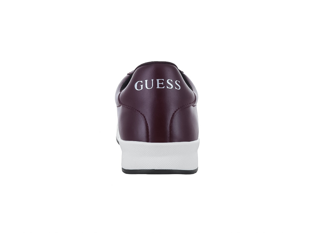 Tenis casuales Guess de color vino con suela blanca y cordones negros.